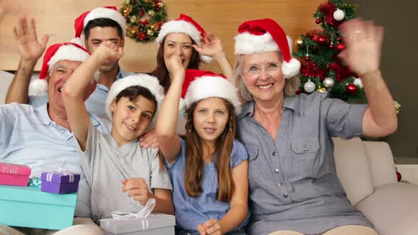 Happy extended family waving at camera at christmas time