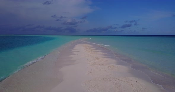 Wide birds eye abstract shot of a paradise sunny white sand beach and aqua blue water background in 