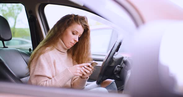 A 30Yearold Woman Receives a Message While Sitting in a Car in a Parking Lot