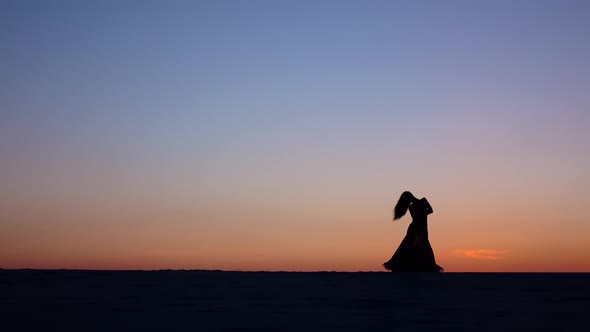 Professional Cute Dancer on the Beach Dances Belly Dancing, Silhouette