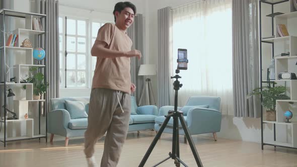 Asian Man Dancing While Shooting Video Content For Social Networks With A Smartphone Camera