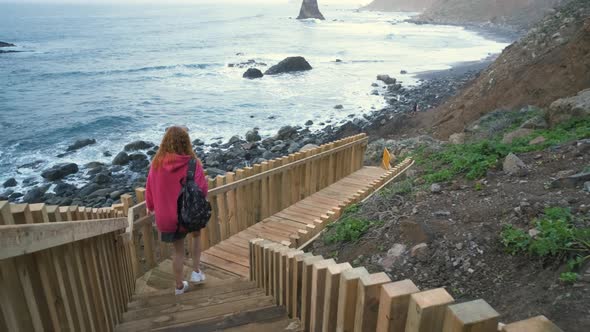 Young Woman Tourist Goes Down the Long Stairs to the Famous Volcanic Black Sand Beach Benijo in the