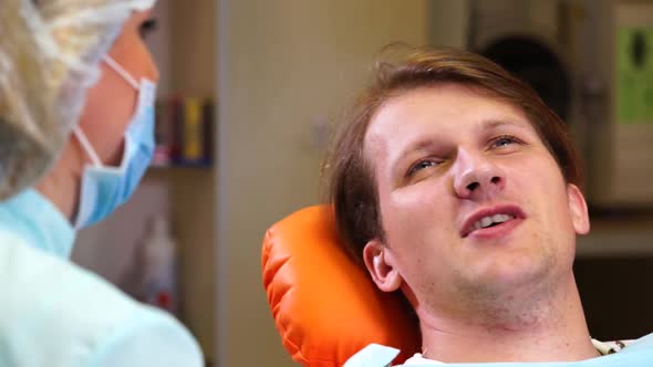 Dentist Talking to Man Patient After Examination