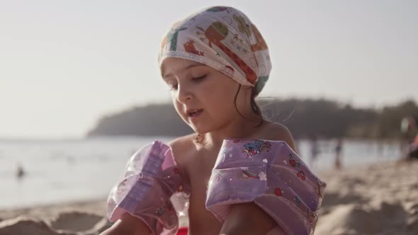 Beautiful Little Girl Playing in Sand On Tropical Beach