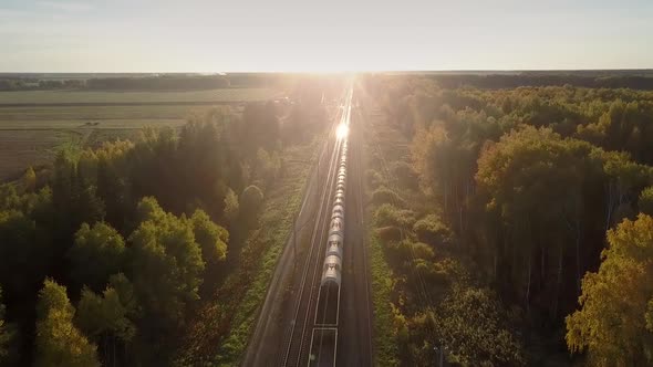 Aerial View Setting Sun Shines on Moving Train Cisterns