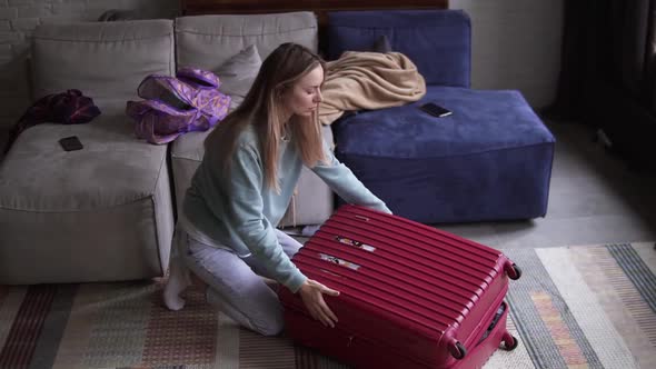 Woman Closing and Zipping Suitcase Getting Ready for Road Trip Preparing Luggage for Vacation in a