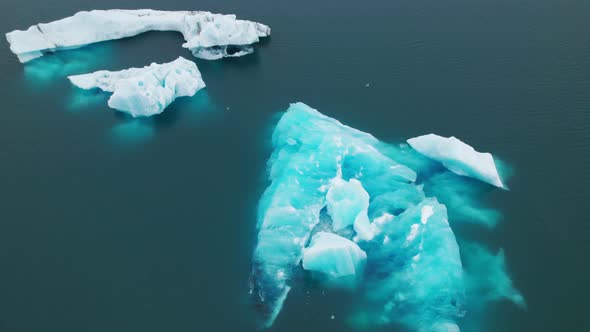 Breathtaking Drone Shot of an Iceberg Melting and Floating in Blue Water