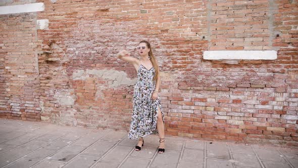Woman Dances Funny in Front of the Brick Wall