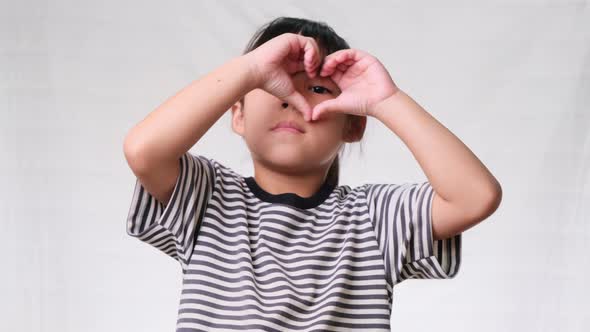 Healthy eyes and vision. Pretty little girl making heart gesture