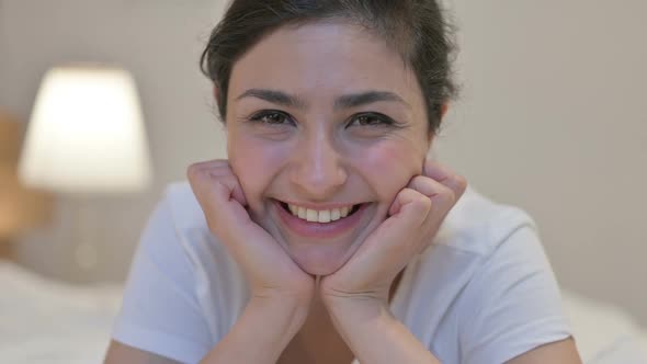 Portrait of Young Indian Woman Smiling at the Camera in Bedroom