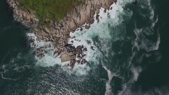 View From a Drone Vertically Down on a Stone Cape Washed By Strong Waves