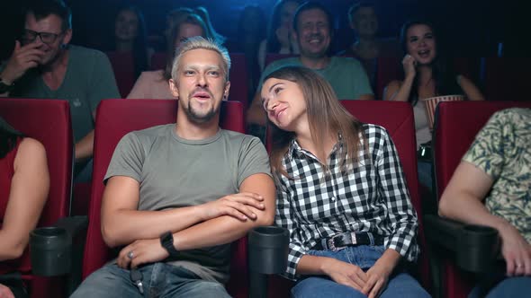 Laughing Couple Having Fun Positive Emotion Watching Comedy Film at Cinema Sitting in Row Spectators