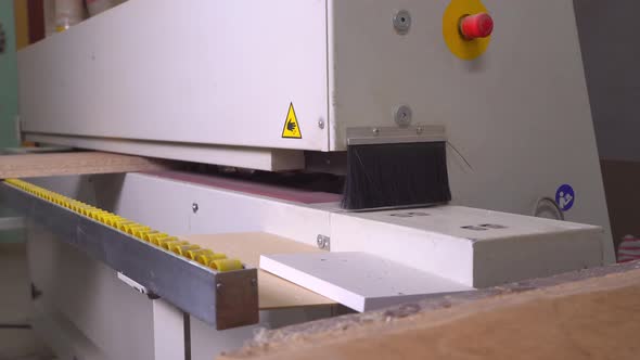 Close-up of a part of a wooden part on an edge-banding machine