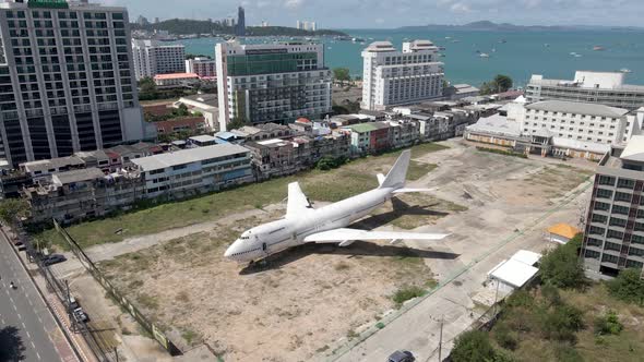 Flyover Boeing 747 parked on Pattaya urban field, Runway 88, Seascape background