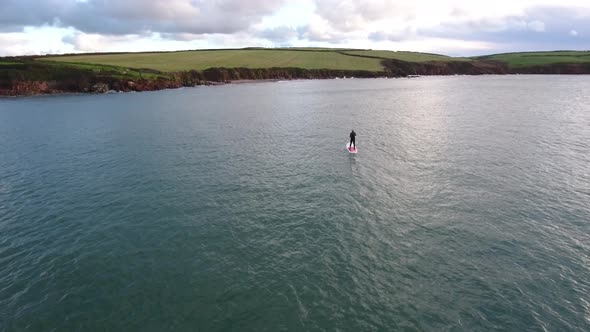 Man doing sport, paddle board, at seaside, aerial view