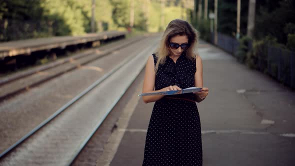 Female Traveler Waiting Train And Looking Town Plan On Navigation Map For Journey. Tourism Adventure