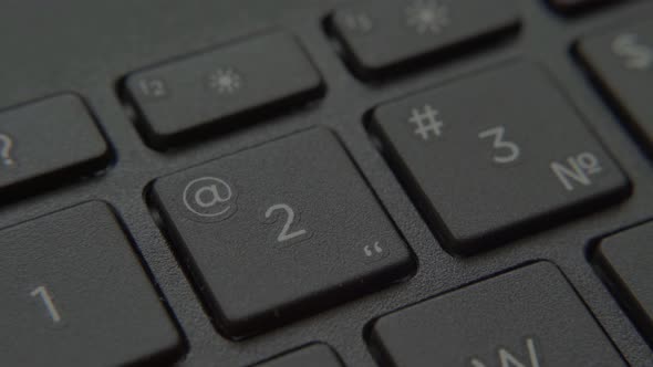 The Finger Presses a Button with a Number on the Keyboard