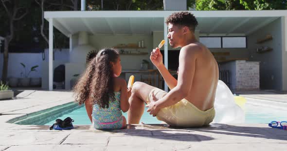 Happy biracial father and daughter spending time at pool together