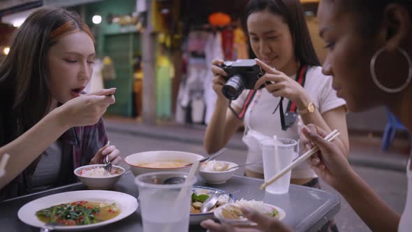 A group of multi-ethnic female friends enjoying street food on Yaowarat Road or Chinatown in Bangkok