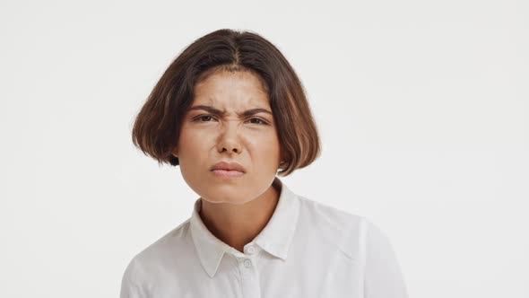 Young Beautiful Brunette East Asian Female in Shirt Looking Suspiciously at Camera Showing