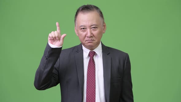 Mature Japanese Businessman Pointing Finger Up