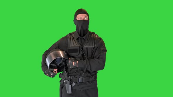 Riot Policeman Standing Holding His Helmet in Hands on a Green Screen Chroma Key