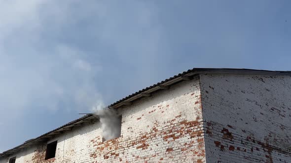 Thick Smoke Coming From the Window of an Old Abandoned Building