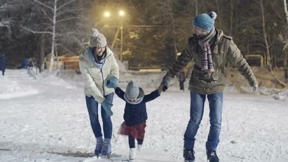 Young Family Ice Skating in Winter
