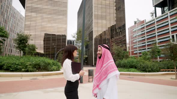 Businesswoman Speaking with Arab Man in Downtown