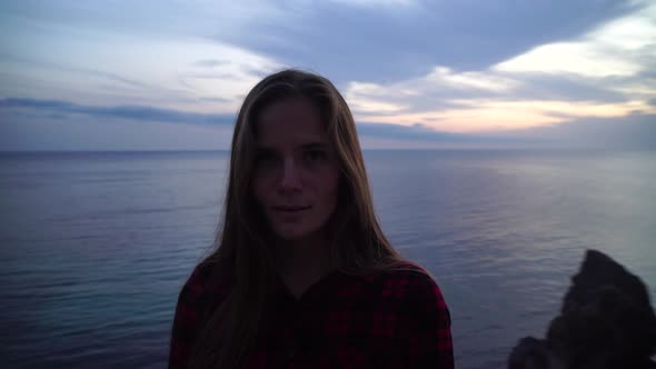 Young Beautiful Sensual Woman Posing High Above the Sea on a Volcanic Rock Like in Iceland