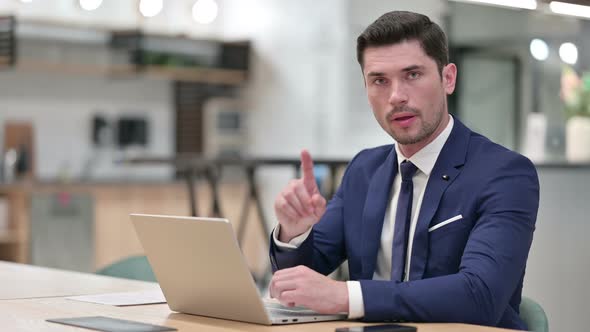 No Sign By Businessman Working on Laptop in Office 