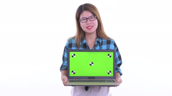 Happy Young Asian Hipster Woman Talking While Showing Laptop