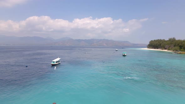 Adisn woman running on wooden jetty of Gili Meno pier during sunshine with epic landscape.Aerial bac