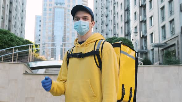 Young Courier Man Showing Thumb Up Gesture and Smiling While Wearing Face Mask for Coronavirus