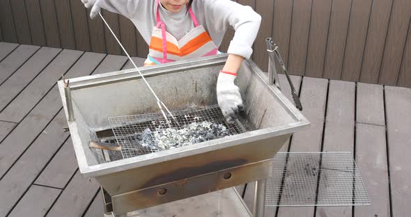 Woman cleaning of barbecue oven