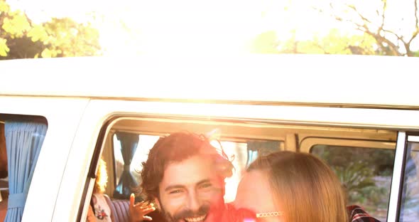 Hipster couple looking out of window of the van