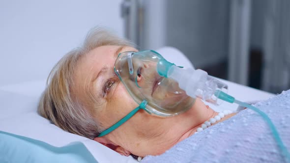 Senior Woman Breathing Slowly with Oxygen Mask