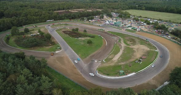 Aerial shot of sport cars driving laps at a closed circuit.