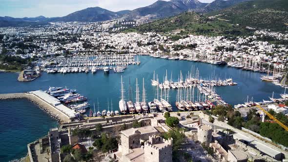 Amazing panoramic view from drone of full of yachts Bodrum harbour and ancient Kalesi castle.