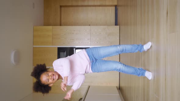 Happy Smiling Mixedrace Preteen Girl Child Dancing Along on Home Kitchen