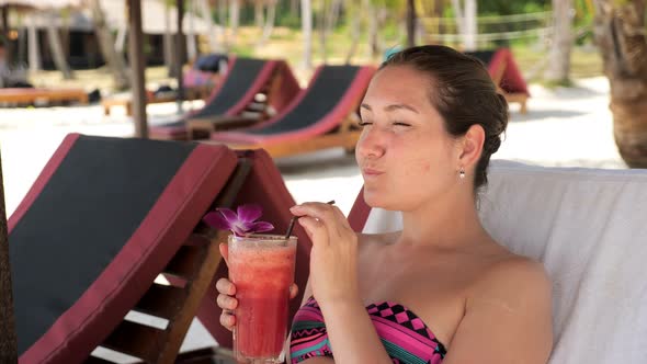 Lady Lies on Sunbed and Drinks Delicious Cocktail Under Shed