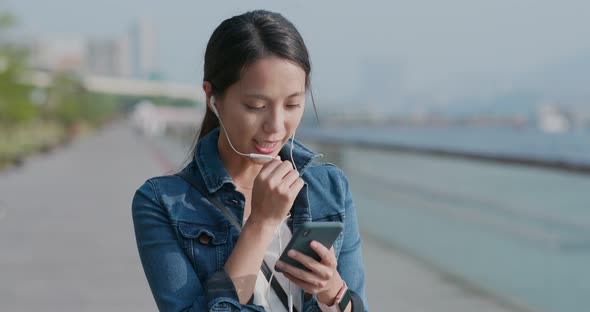 Woman talk to earphone on cellphone in the city