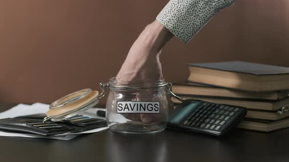 Businessman Taking Money From Glass with Savings