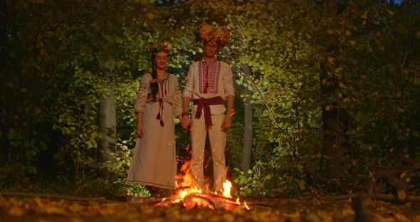 Beautiful Couple in National Slavic Costumes Stand By the Fire and Hold Hands the Wedding Ceremony