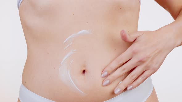 Female Applying Body Lotion on Her Belly