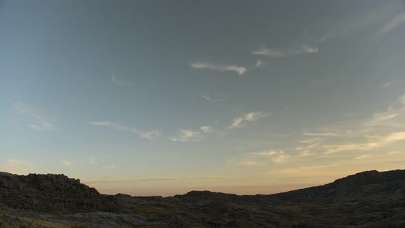 Day to night time lapse over rugged landscape