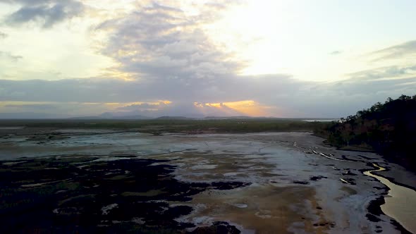 Drone rises straight up revealing large open salt pans and mud flats and the saltwater Bohle River i