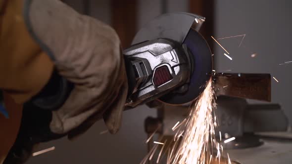 Professional welder in protective helmet in workshop