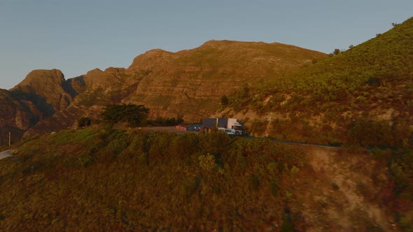 Forwards Fly Above Mountain Landscape Lit By Setting Sun