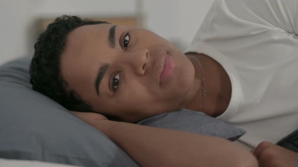 African Woman Talking on Video Call While Laying in Bed